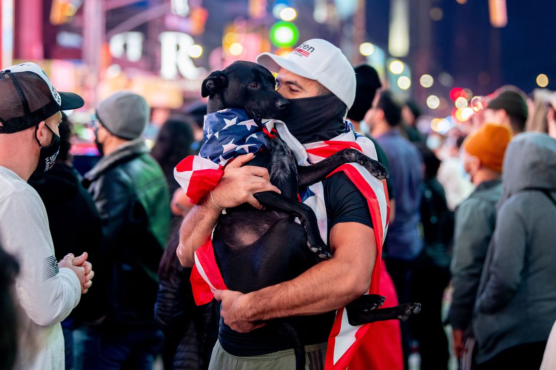 A man and dog wear American flags
